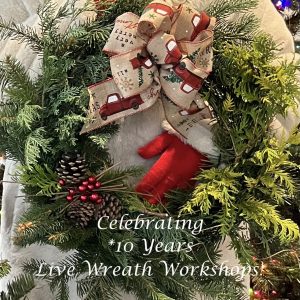 a gloved person holding a wreath they made at the workshop