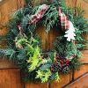 A holiday wreath hanging on a gate